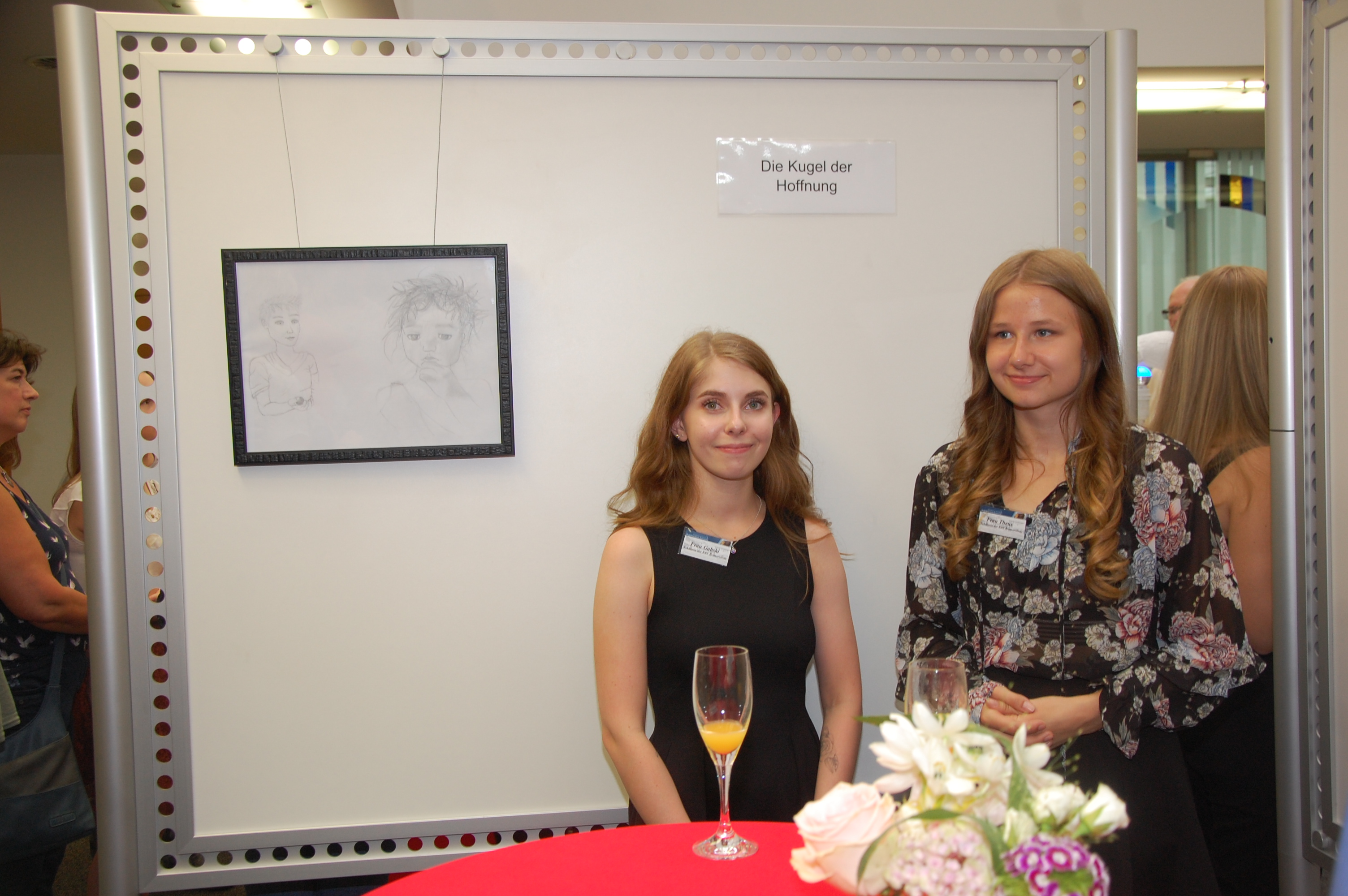 Zwei Schülerinnen stehen vor ihrem Ausstellungsplatz auf der Vernissage