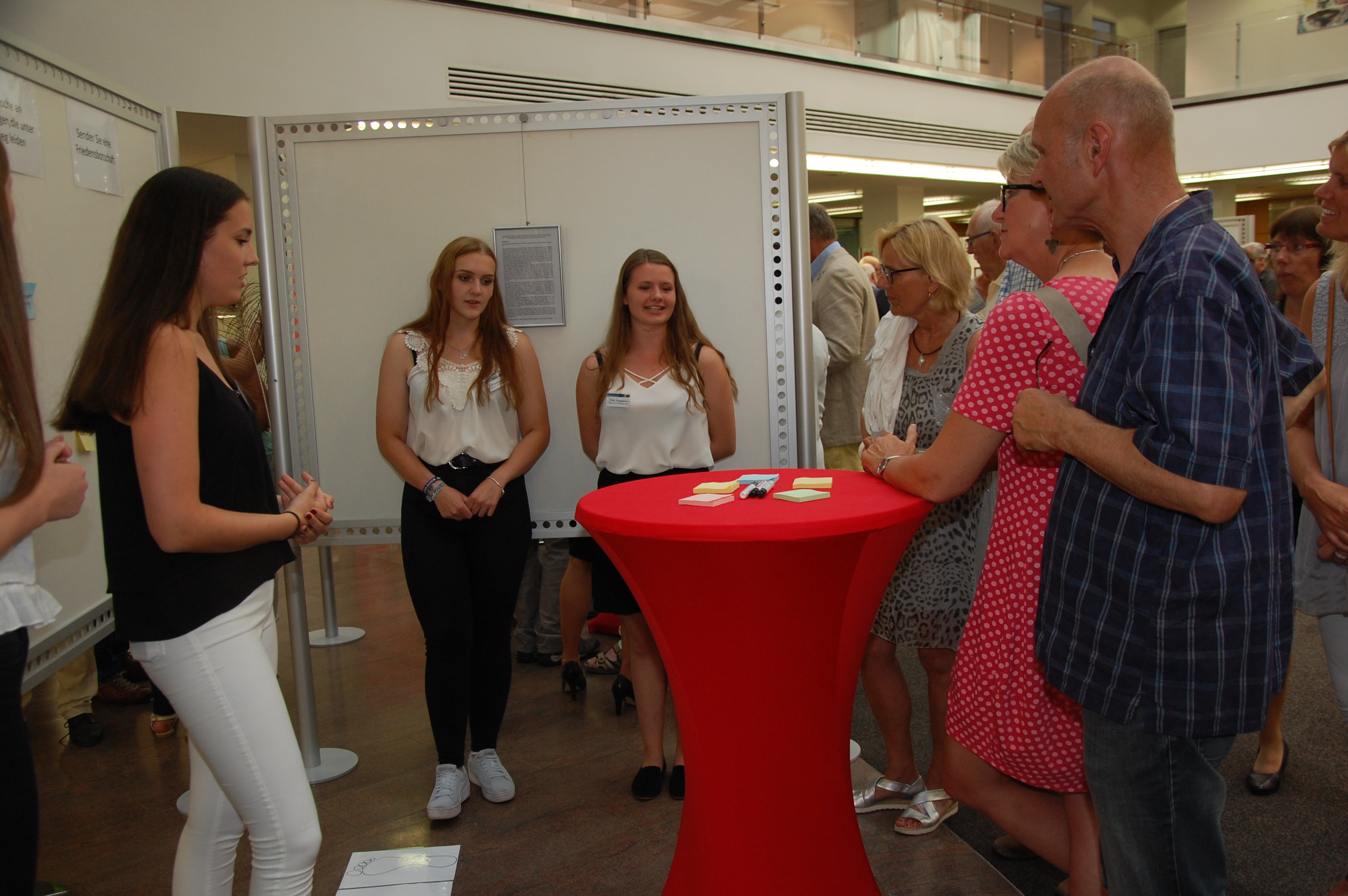 Drei Schülerinnen erklären den Besuchern der Vernissage ihre Idee